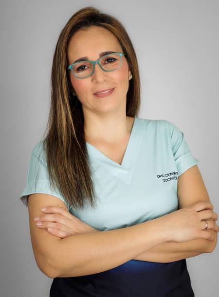 Consultorio odontológico moderno con una silla dental reclinada, equipo médico y mobiliario blanco en un entorno limpio y bien iluminado